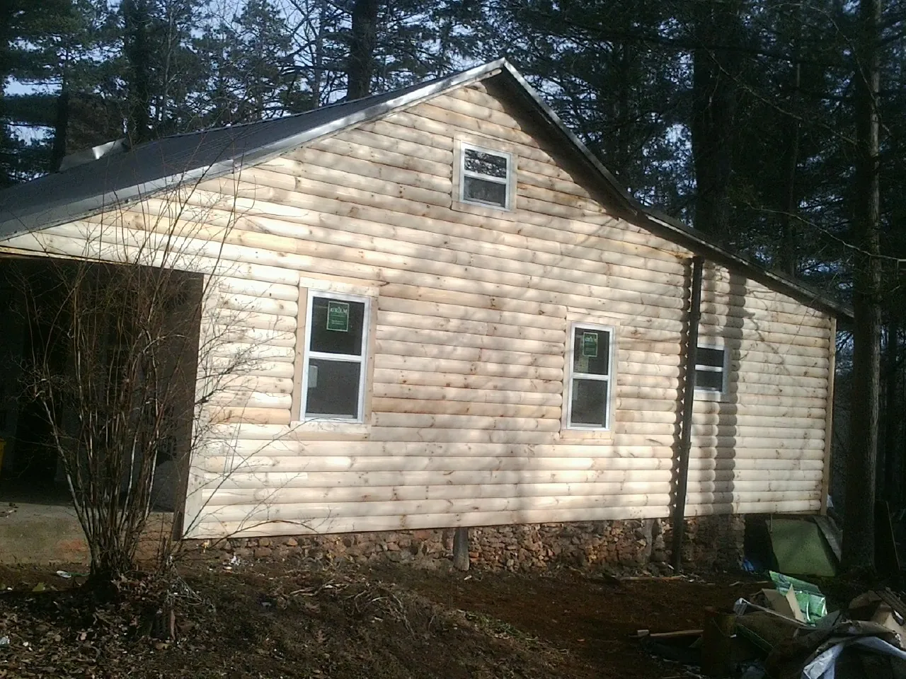 New log siding and dark metal roofing on a gable end in Cranberry Township