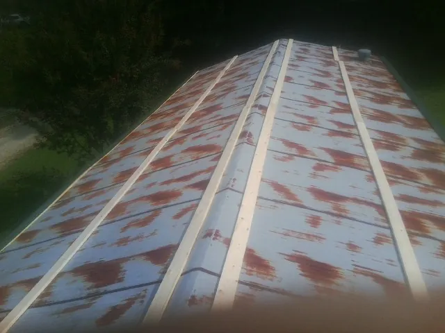 Rusted metal roof panels with new wood purlins before replacement — Storm Damage Roof Repair in Cranberry Township by Roofing Brothers