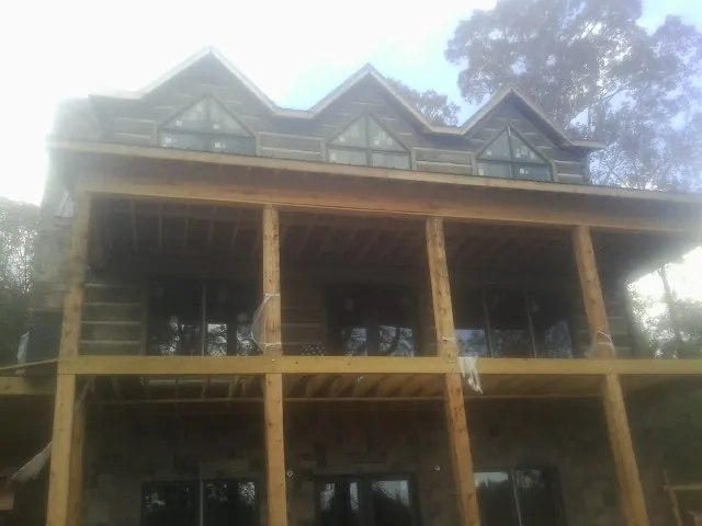 Dormers and porch framing on a large log home under construction — Roof Coating work by our crew in Cranberry Township