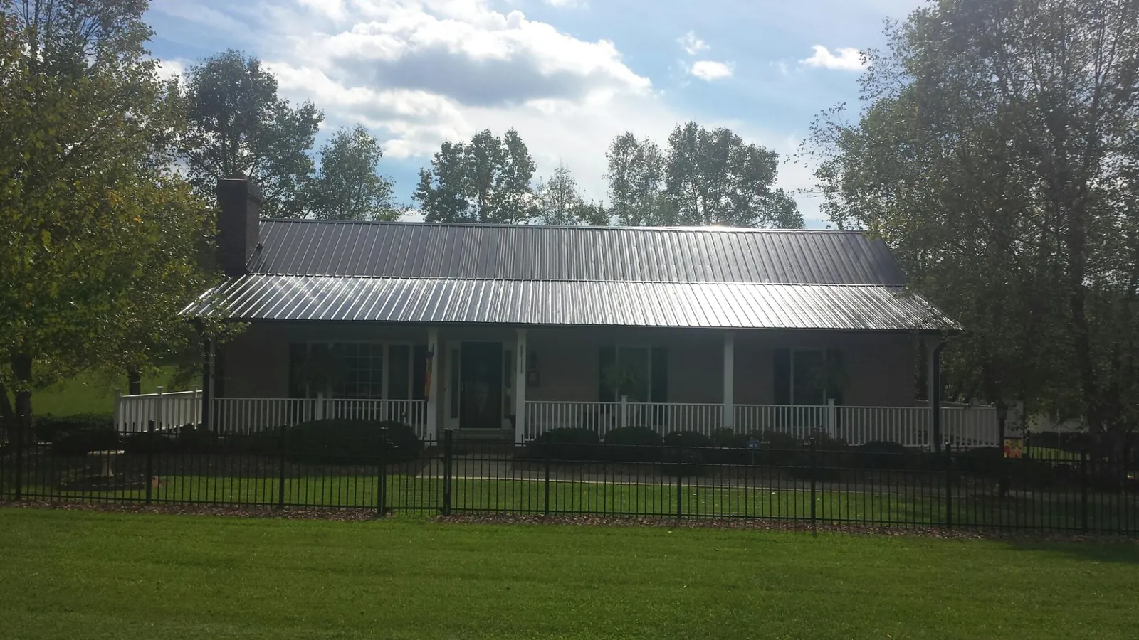 Gray metal roof on a brick ranch with a full width front porch — Gutter Guard Installation work by our crew in Cranberry Township