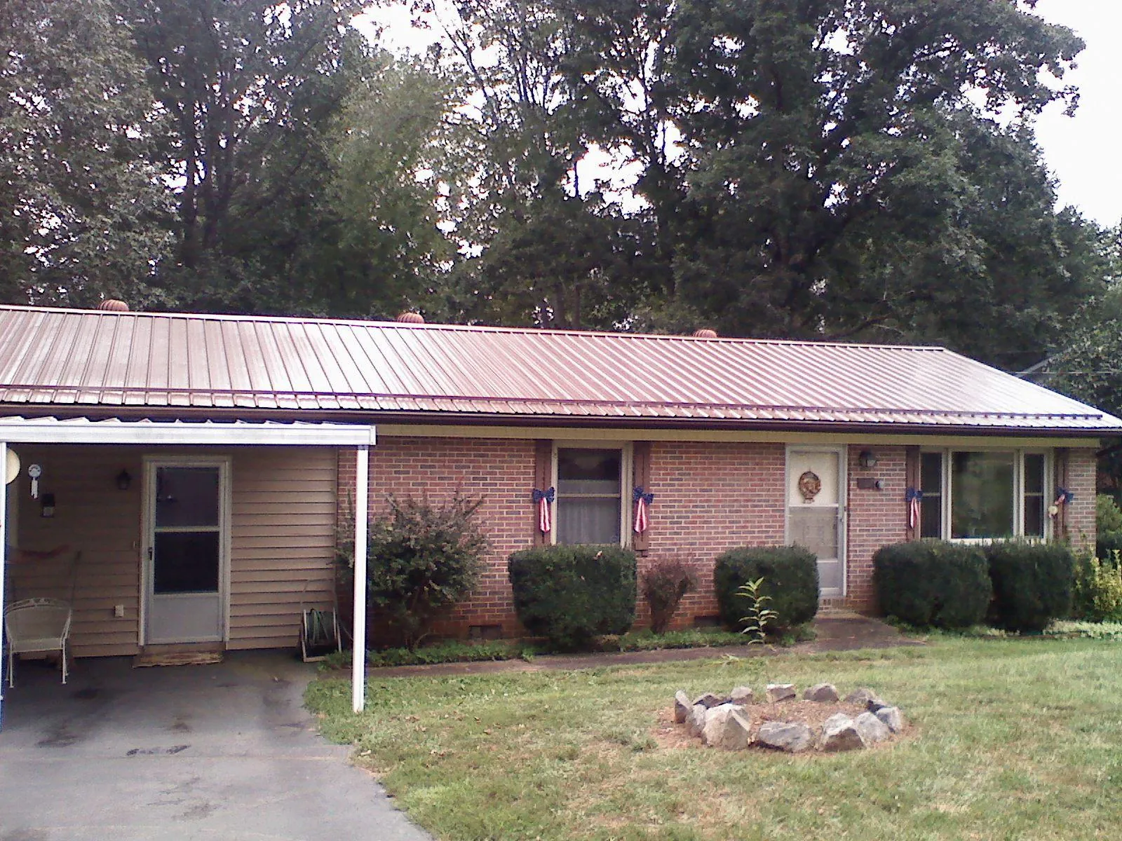 Bronze metal roof and carport on a brick ranch home — Roof Repair work by our crew in Cranberry Township