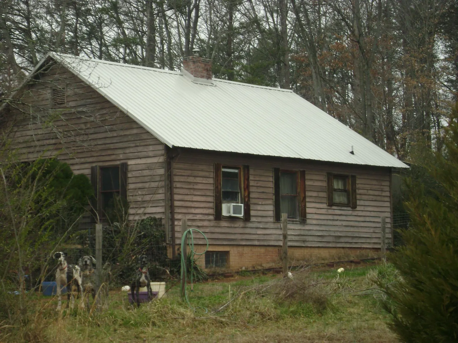 White metal roof on an old wood sided farmhouse, from a Metal Roof Installation job in Cranberry Township